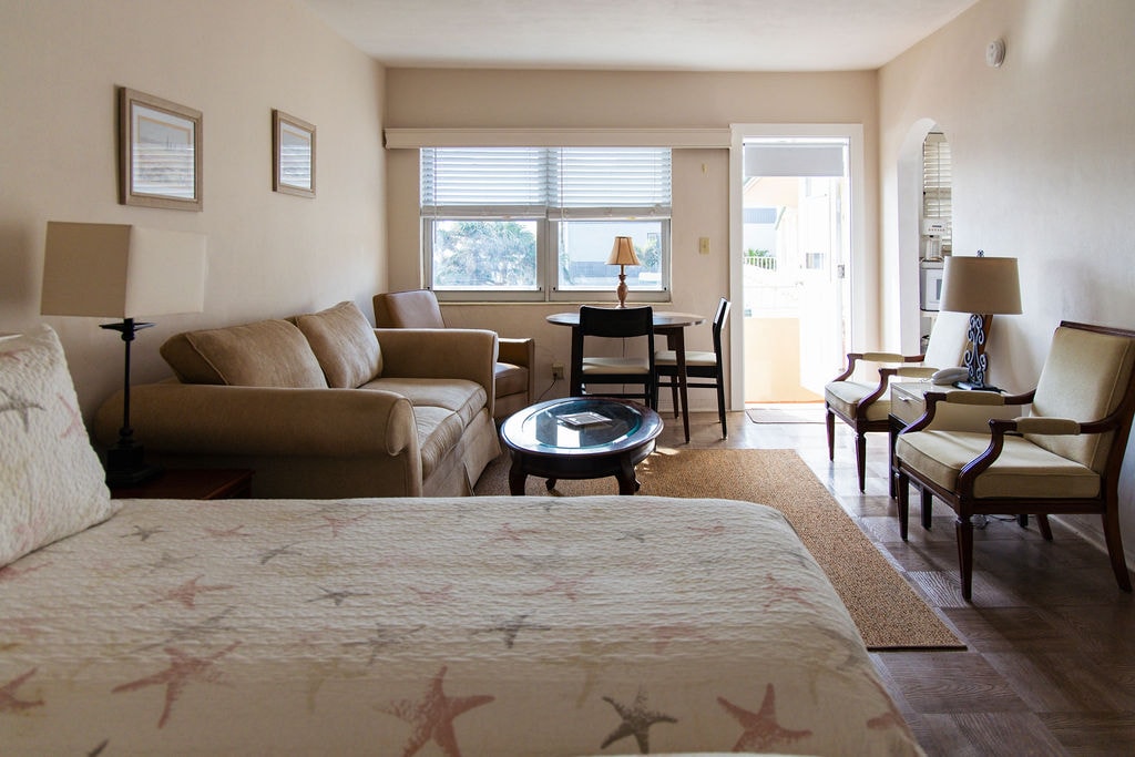 Spacious Bel-Aire efficiency apartment with king bed, sofa, dining area, and patio door