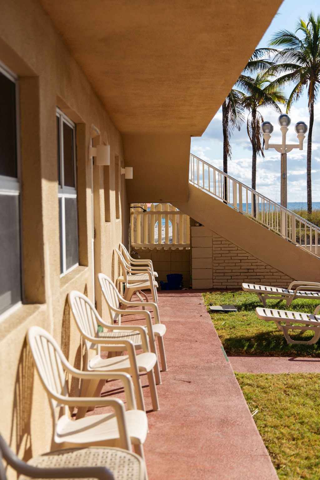 Outdoor patio with lounge chairs and ocean view at Bel-Aire Beach Apartments